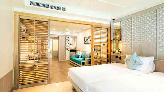 Hotellrom med dobbeltseng, blå sofa og tredetaljer. (AI-generert tekst)