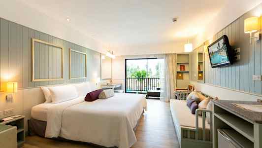 Et romslig hotellrom med moderne møbler og en balkong. (AI-generert tekst)