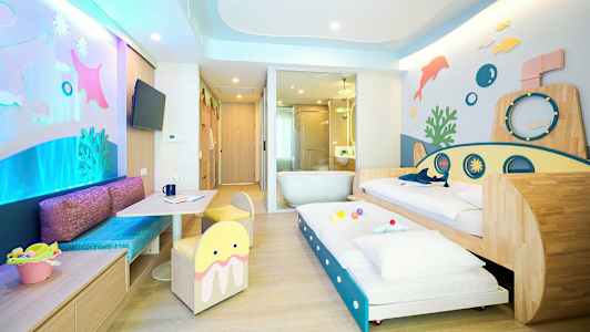 Et fargerikt familierom med undervannstema, inkludert senger og lekeområde. (AI-generert tekst)