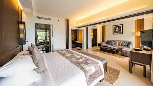 Lyst hotellrom med dobbeltseng og sittegruppe. (AI-generert tekst)