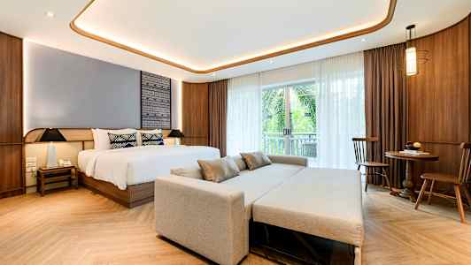 Rom med en seng, sofa og spisebord. (AI-generert tekst)