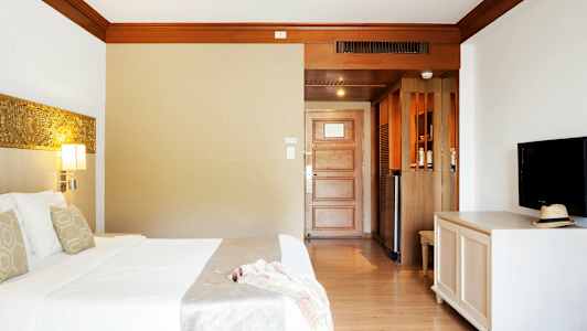 Hotellrom med seng, TV og dør. (AI-generert tekst)