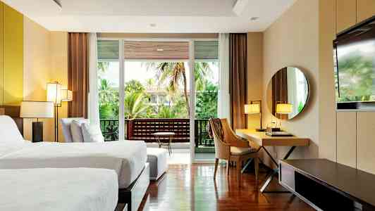 Moderne hotellrom med to enkeltsenger, skrivebord, speil og balkong med grønn utsikt. (AI-generert tekst)