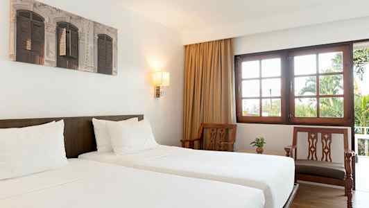 Hotellrom med to enkeltsenger og møbler i lyst tre. (AI-generert tekst)