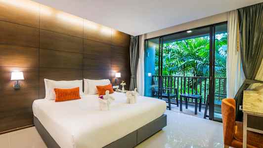 Et hotellrom med en stor seng, dekorerte håndklessvaner, en balkong med utsikt over grøntområder. (AI-generert tekst)