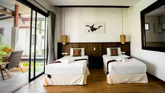 Dobbeltrom med to enkeltsenger, vindu og dekorerte puter. (AI-generert tekst)