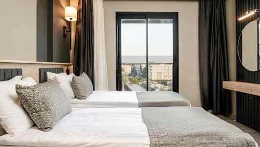 Rom med to enkeltsenger, moderne innredet med en nøytral fargepalett. (AI-generert tekst)