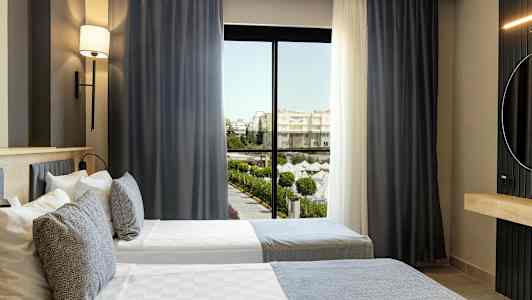 Hotellrom med to enkeltsenger og vindu med utsikt mot et bassengområde. (AI-generert tekst)