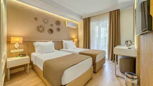 Et hotellrom med to enkeltsenger, en skrivebordskrok og nøytrale fargetoner. (AI-generert tekst)