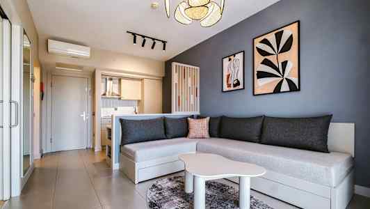 Moderne innredet rom med kjøkken, sofa og veggdekorasjoner. (AI-generert tekst)