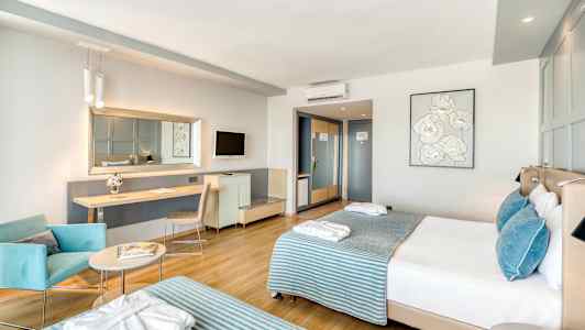 Moderne hotellrom med to senger, sitteplass og arbeidsbord. (AI-generert tekst)