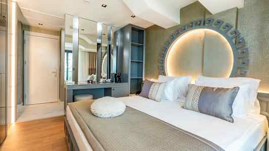 Moderne hotellrom med seng, skrivebord og dekorativ belysning. (AI-generert tekst)