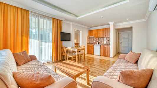 En stue med to sofaer, et sofabord, en spisegruppe og et åpent kjøkken. (AI-generert tekst)