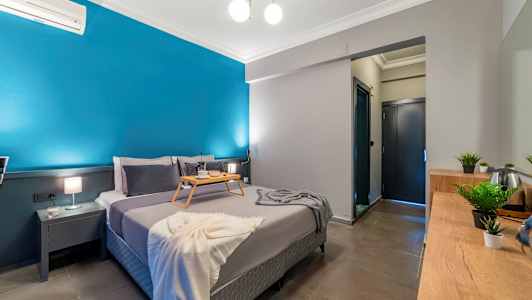 Soverom med en dobbeltseng, et brettbord, blå vegg og interiør. (AI-generert tekst)