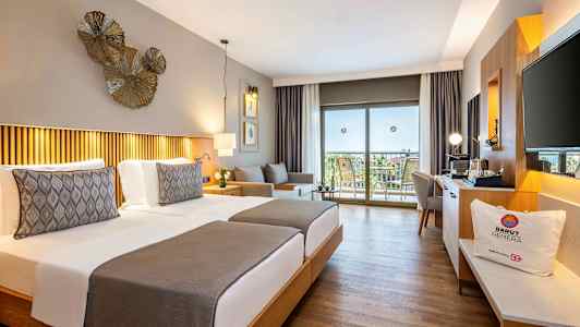 Hotellrom med to enkeltsenger, dekorativ belysning og utsikt over en balkong med møbler. (AI-generert tekst)