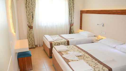 Hotellrom med to enkeltsenger, lys gardiner og et speil. (AI-generert tekst)