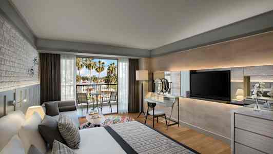 Moderne hotellrom med balkong og utsikt til palmer. (AI-generert tekst)