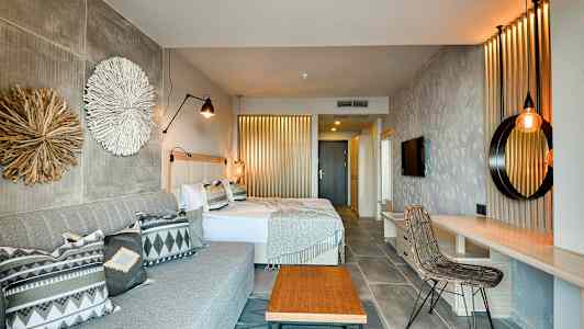 Et hotellrom med to senger, en sofa og interiørdetaljer. (AI-generert tekst)