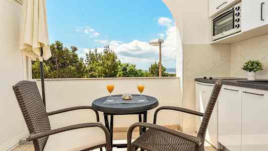 Balkong med bord, stoler og utsikt. (AI-generert tekst)