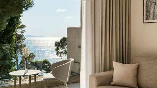 Lyst og moderne hotellrom med havutsikt fra balkongen. (AI-generert tekst)