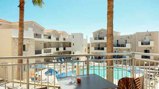 Hotellbygning med balkonger og basseng, sett fra en terrasse. (AI-generert tekst)