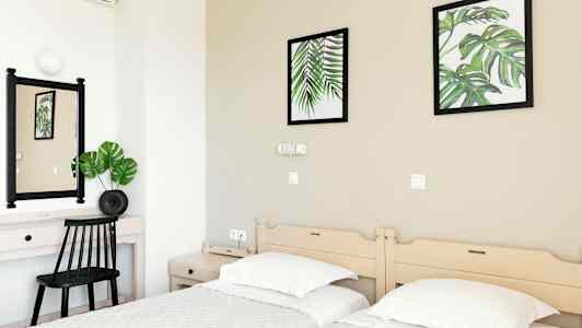 Hotellrom med to enkeltsenger, et skrivebord og veggdekorasjoner med botaniske motiver. (AI-generert tekst)