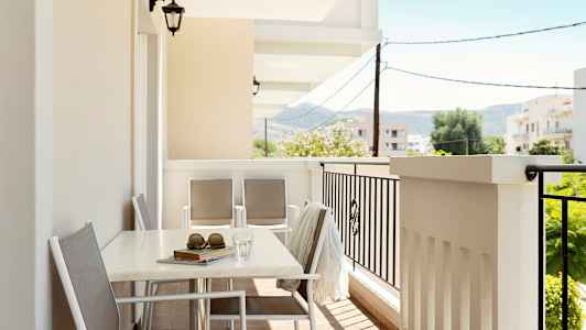 En møblert balkong med utsikt mot omgivelsene. (AI-generert tekst)