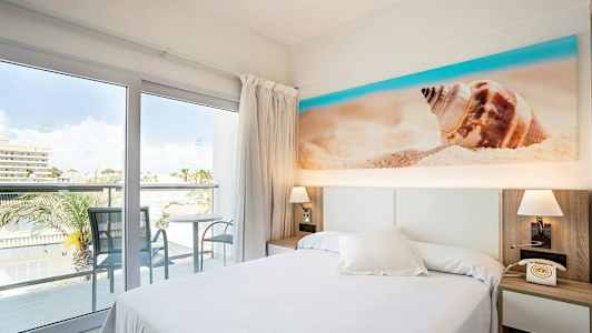 Hotellrom med balkong og utsikt, seng og dekorasjon med strandmotiv. (AI-generert tekst)