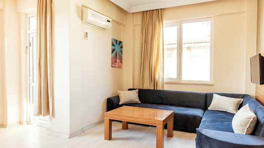 En stue med blå sofa, trebord og to vinduer. (AI-generert tekst)