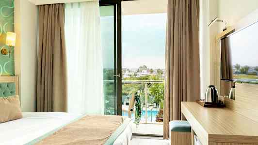 Hotellrom med balkong som har utsikt over bassengområdet. (AI-generert tekst)