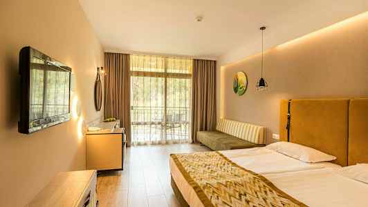 Et hotellrom med en dobbeltseng, en sofa, en TV og en balkong. (AI-generert tekst)