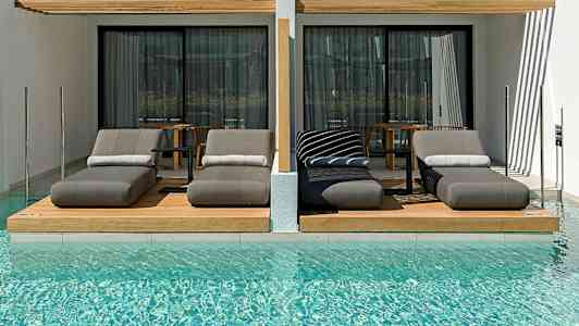 Luksuriøse solsenger ved et basseng foran moderne hotellrom. (AI-generert tekst)