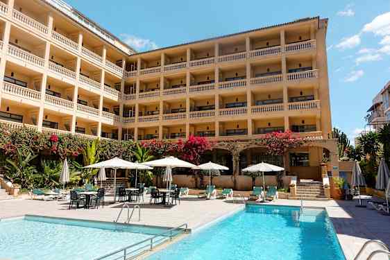 Hotell med flere etasjer og balkonger, bassengområde med solsenger og parasoller. (AI-generert tekst)