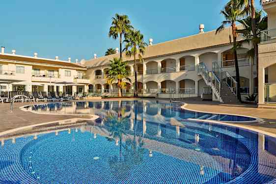 Bilde av et hotellbasseng med solsenger og bygninger i bakgrunnen. (AI-generert tekst)