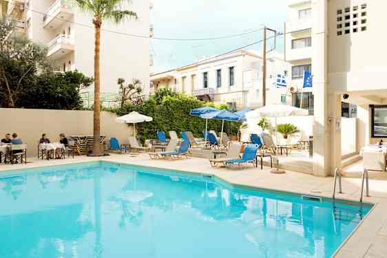 Et utendørs svømmebasseng med solsenger og parasoller rundt. (AI-generert tekst)