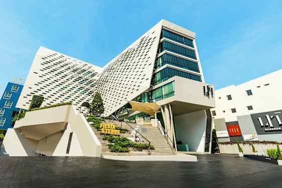 Moderne bygning med unik arkitektur, store glasspartier og en skrå fasade. (AI-generert tekst)