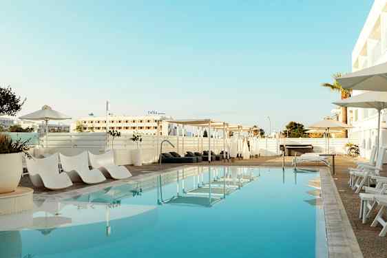 Utendørsbasseng med solsenger og parasoller ved hotellet. (AI-generert tekst)