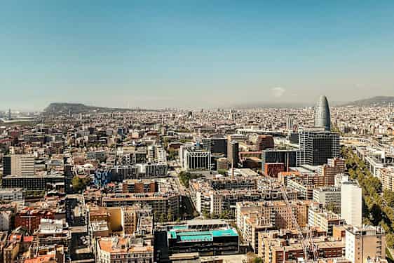 Utsikt over en by med flere bygninger og en unik høy bygning synlig. (AI-generert tekst)