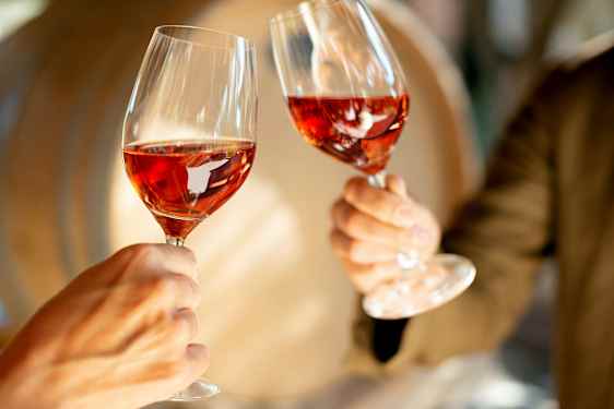 To glass med rosévin holdes opp. (AI-generert tekst)
