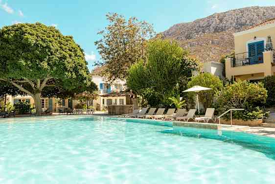 Et utendørsbasseng omgitt av solsenger og grøntområder. (AI-generert tekst)