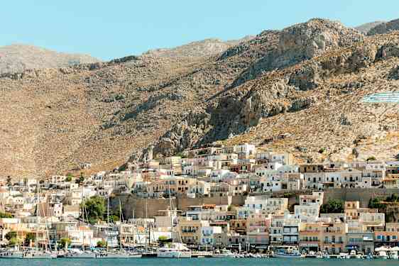 En kystby med små hus på en fjellskråning. (AI-generert tekst)