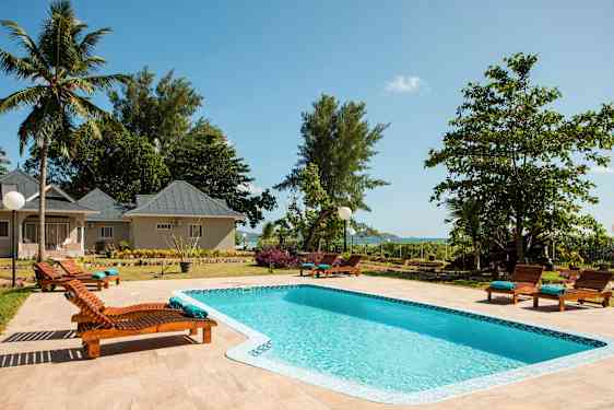 Storbild av et basseng omgitt av solsenger på en anlegg. (AI-generert tekst)