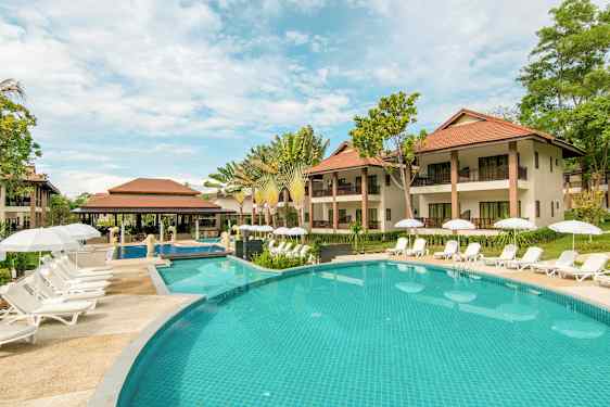 Utsikt over bassengområde med solsenger og parasoller foran hotellbygninger. (AI-generert tekst)