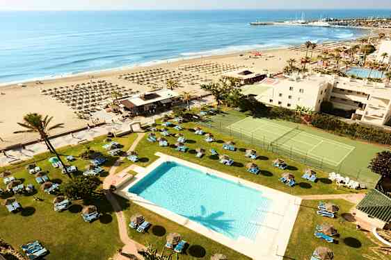 Hotellbassengområdet med utsikt over stranden og havet. (AI-generert tekst)