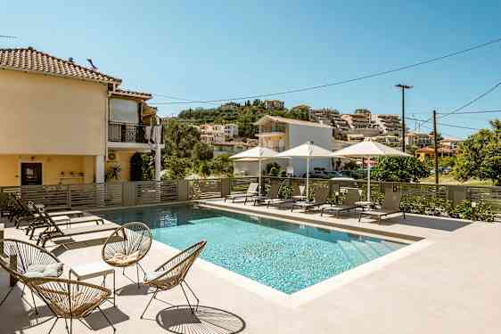 Utendørsbasseng med solsenger og parasoller ved et boligområde. (AI-generert tekst)