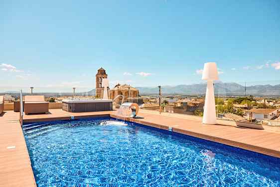 Utendørs svømmebasseng med utsikt over byen og fjellene. (AI-generert tekst)