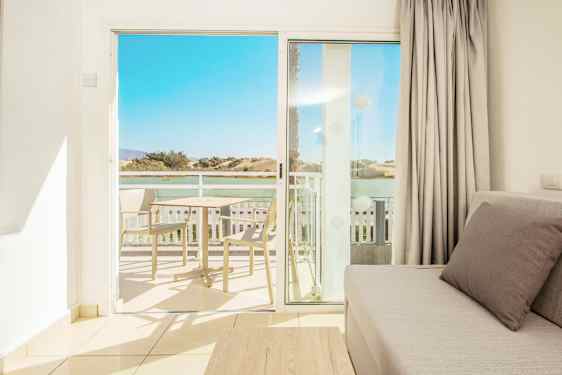 Utsikt fra en stue mot balkongen og landskapet i bakgrunnen. (AI-generert tekst)