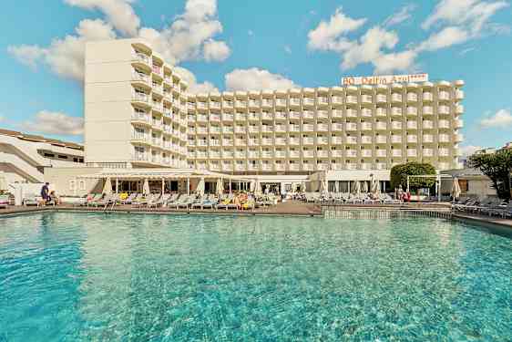 Bilde av en hotellbygning med et basseng i forgrunnen. (AI-generert tekst)