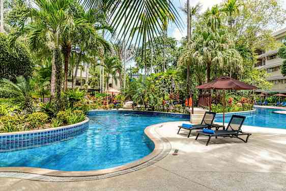 Bilde av et utendørs svømmebasseng omgitt av tropiske planter og solsenger. (AI-generert tekst)