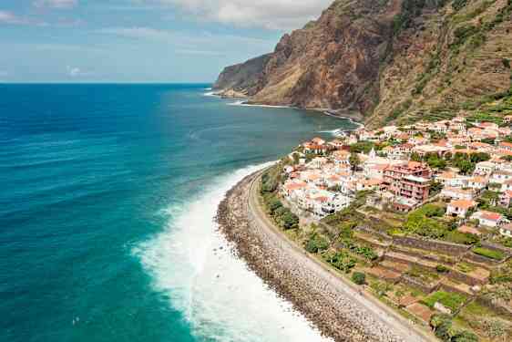 Utsikt over en kystlinje med en by på klippen og havet i bakgrunnen. (AI-generert tekst)